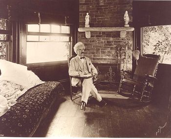 Mark Twain seated writing