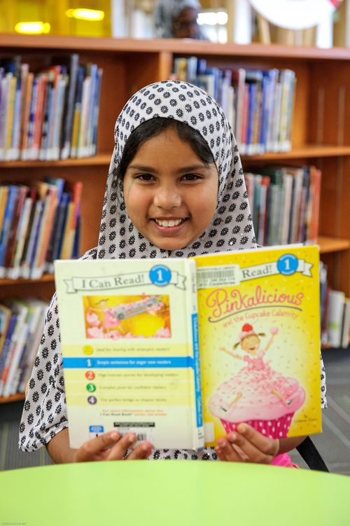 Club participant enjoying a book at the library
