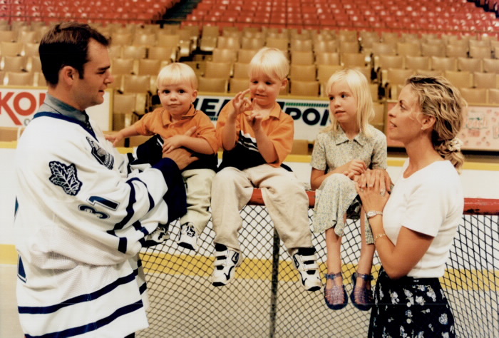 Hockey player Curtis Joseph his wife and three children sitting on a hockey goal Hockey player Curtis Joseph his wife and three children sitting on a hockey goal