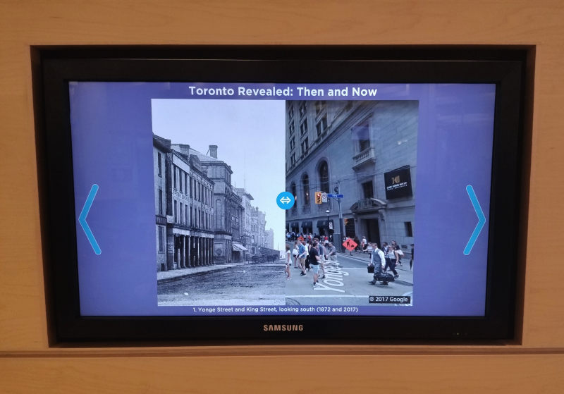 Image of a screen in the gallery with an interactive before and after image of a city view