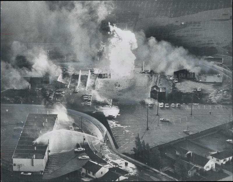 Aerial view of a fire and burnt buildings and a firefighters spraying water Aerial view of a fire and burnt buildings and a firefighters spraying water