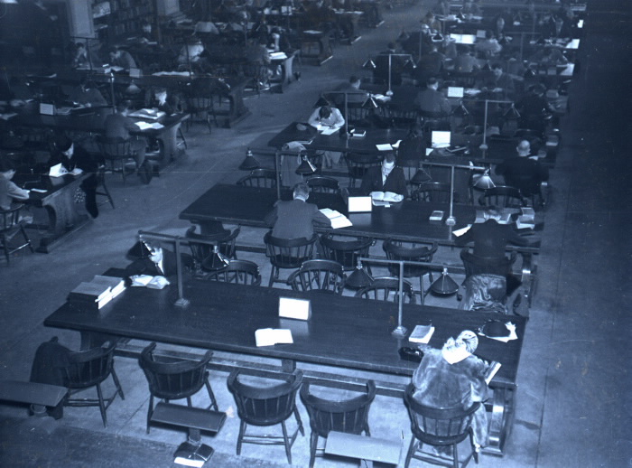 Blue-tinted old photo of busy library reading room