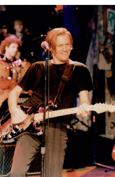 Man playing electric guitar in a performance venue Man playing electric guitar in a performance venue