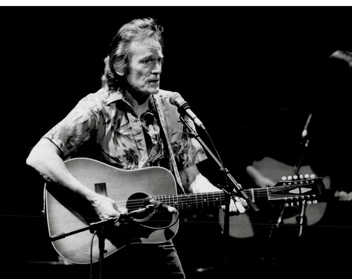 Man with acoustic guitar playing on dark stage Man with acoustic guitar playing on dark stage