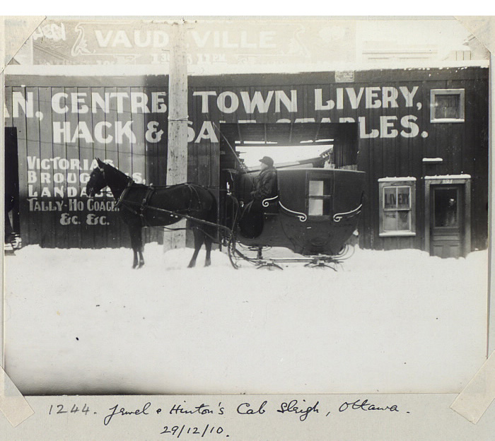 Snowy street with a horse and carriage resting in front of buildint Snowy street with a horse and carriage resting in front of buildint