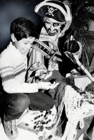 Pirate captain David Mathews shows little brother Talim Rahaman 10 some booty at the Royal York by Boris Spremo