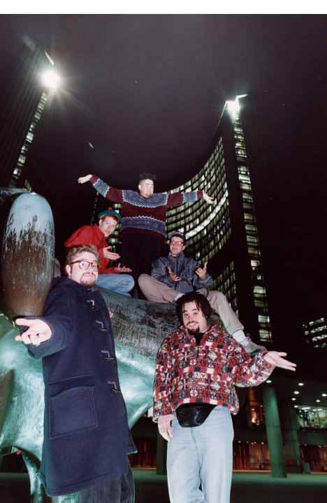 Five young men posing on statue in front of Toronto City Hall at night Five young men posing on statue in front of Toronto City Hall at night
