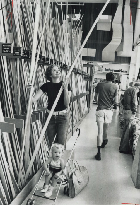 1976 vintage photo Mrs. Debi Cushing; with daughter Dana buying some lumber at Lansing Buildall's store