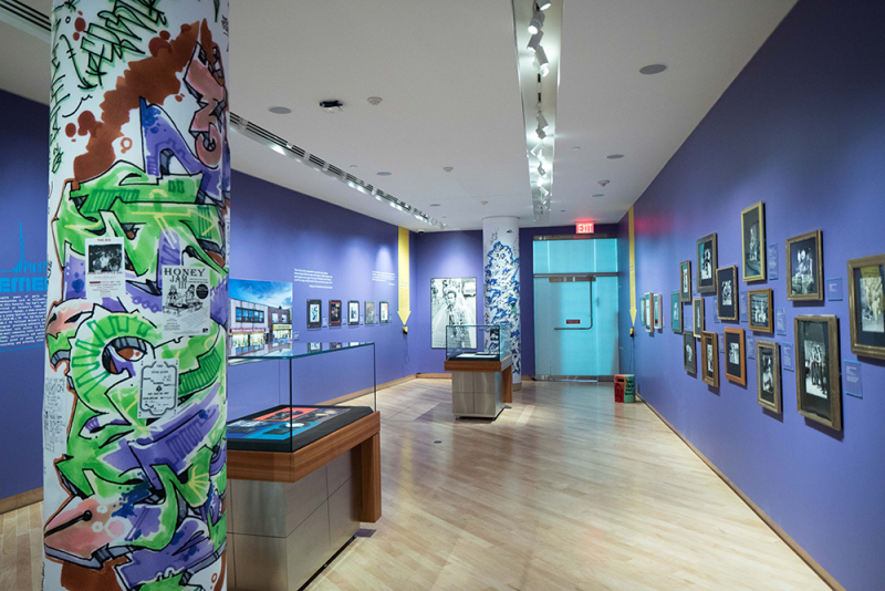 Interior of exhibit with items on walls and records in cases as well as a tagged column