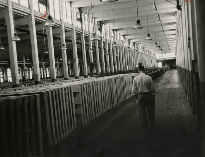 Empty factory with man walking down hallway