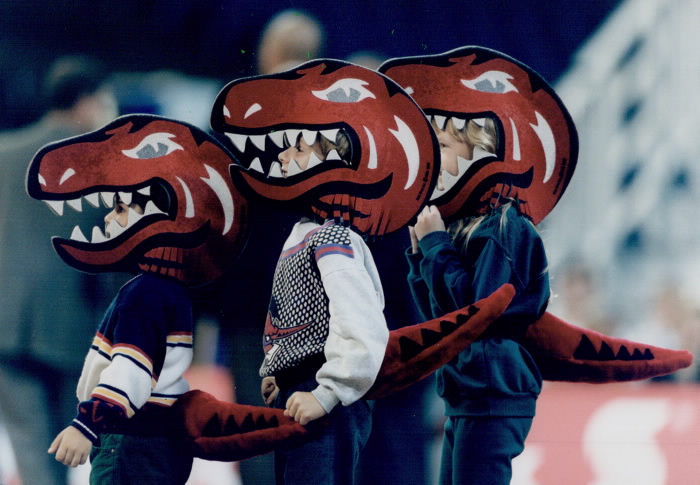 Kids with Raptors mascot head masks watching game