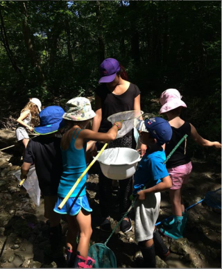 Broti and children examining what's in their nets outside.