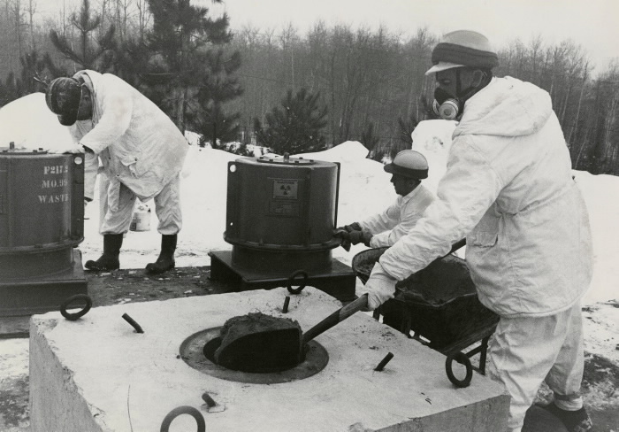 Workers dispose of nuclear waste by burying it in underground repositories.