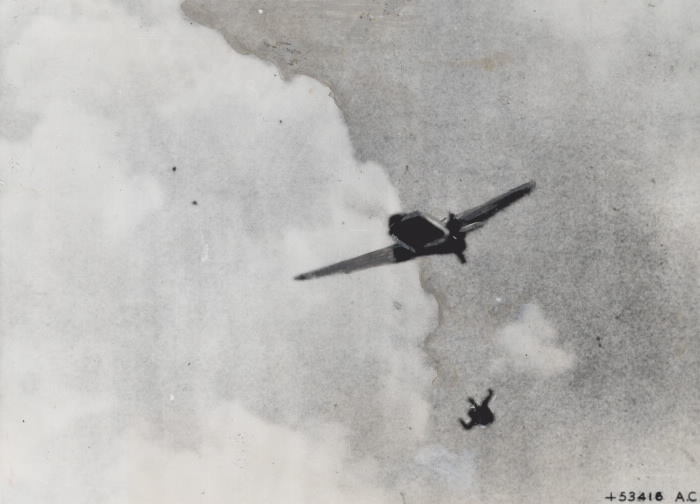 A German fighter pilot ejects himself from his plane while under fire from Allied forces.
