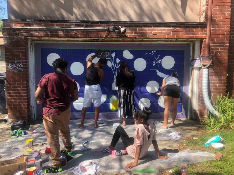 Youth working on the FCJ garage door mural