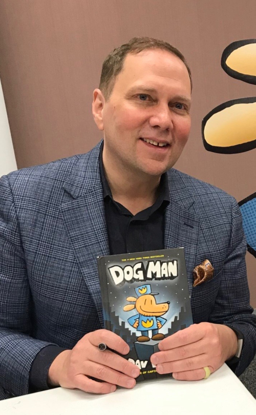 Dav Pilkey holding Dog Man book