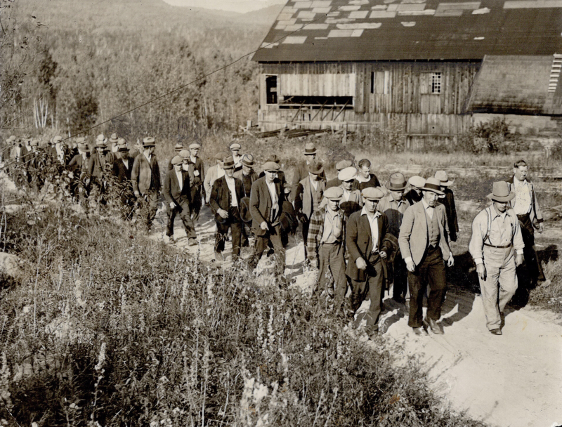 Men marching in grassland in working clothes