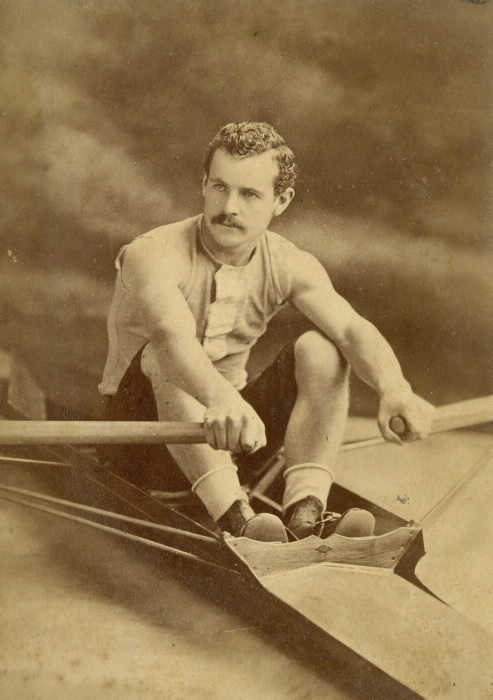 Homme posant en bateau à rames d’époque