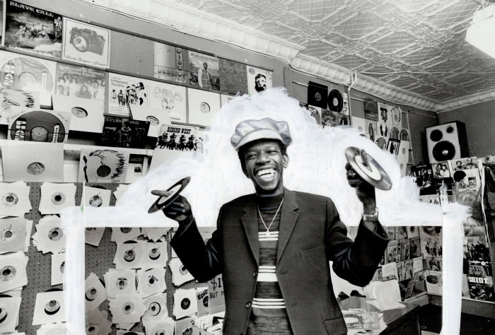 Homme faisant reposer des disques sur ses doigts dans un magasin de disques