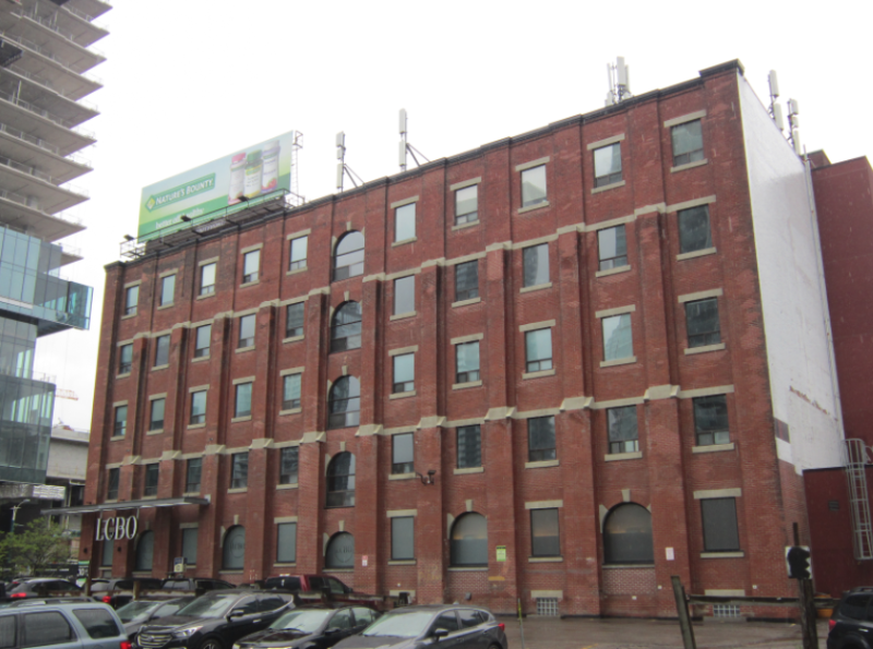 Larger brick building with LCBO sign and cars parked in front