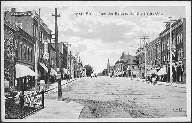 Main street of small town with businesses and a horse and buggy.