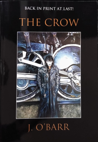Book cover of The Crow with illustration of person in trench coat with white face in front of large industrial wheels
