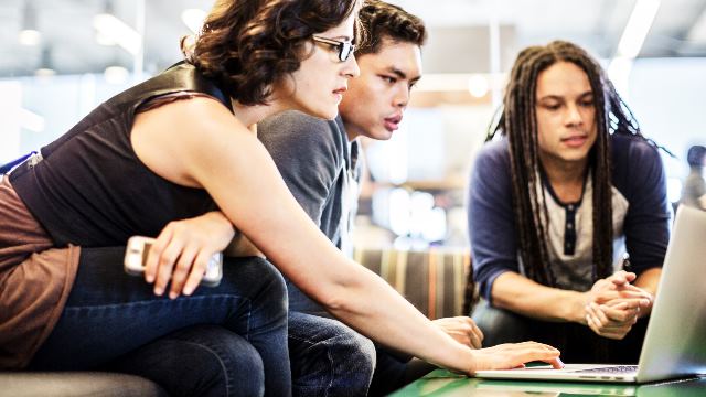 Three learners with a laptop