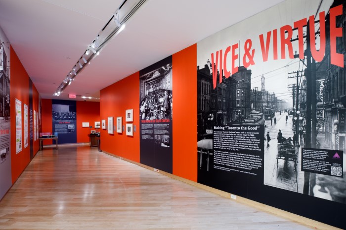 Gallery interior with enlarged black and white photographs on walls. Title of exhibit appears at top. 