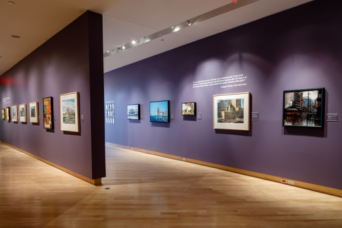 Interior image of the gallery with large framed paintings on the wall.