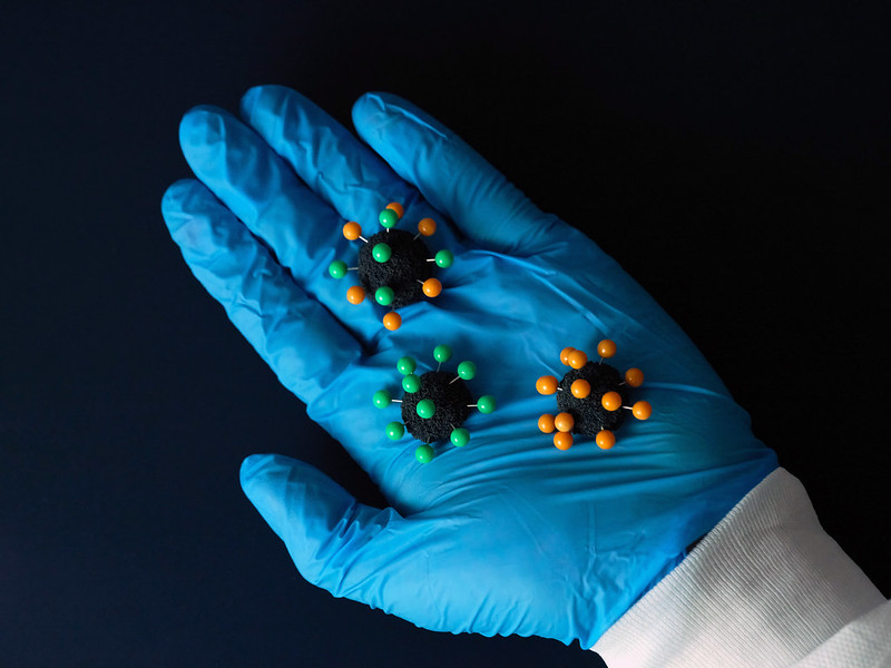 Gloved hand holding model viruses