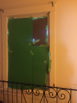 Window covered in paper with a small hole