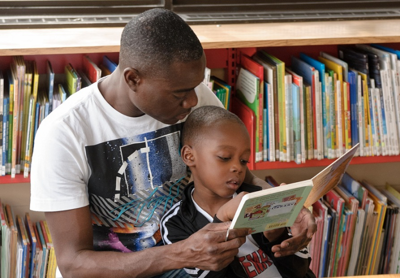 Adult and child reading together