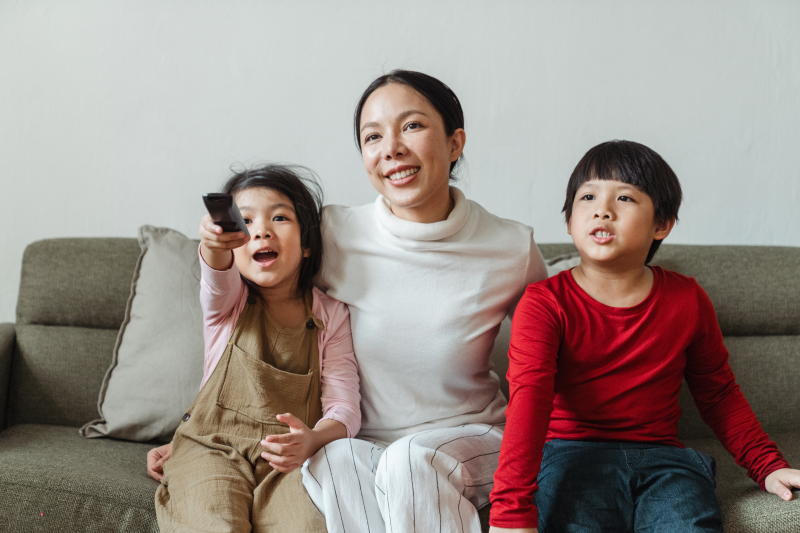 Adult and two children watching television together