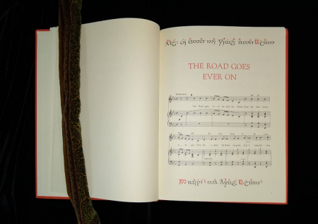 Book open to page of musical notation for poem "The Road Goes Ever On"