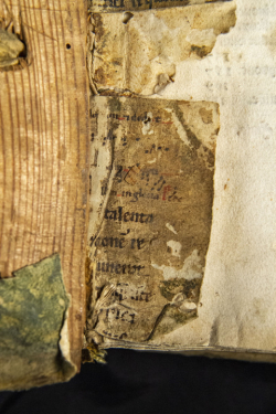 Opened vintage book with lots of wear with bits of pages pasted on