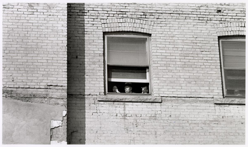 Man looks out window at festive event Man looks out window at festive event