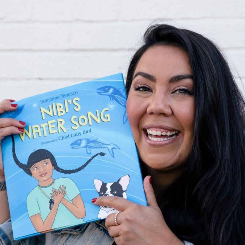 Author Sunshine Tenasco holding book Nibi's Water Song