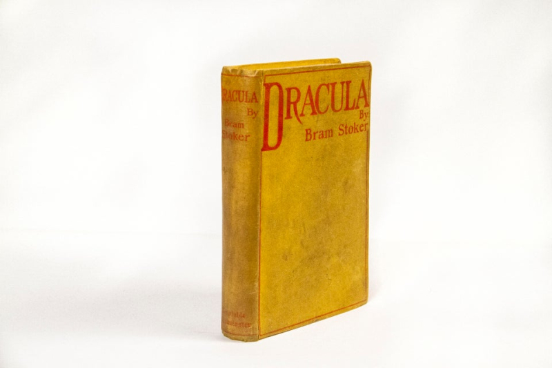 A bright yellow hardcover of a book with a thin red border. The title at top reads Dracula