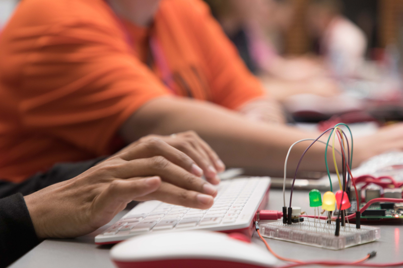 Person typing on a keyboard with an Arduino mini-controller nearby.