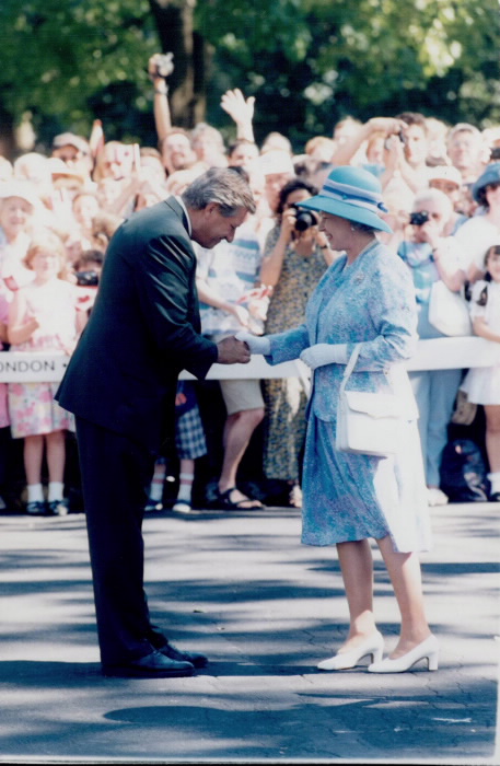 Mike Harris shakes hands with the Queen in front of onlookers