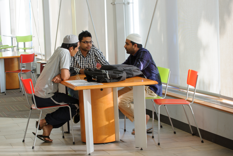 Adults having conversation at a table at the library.