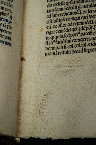 Portion of opened book with markings near spine