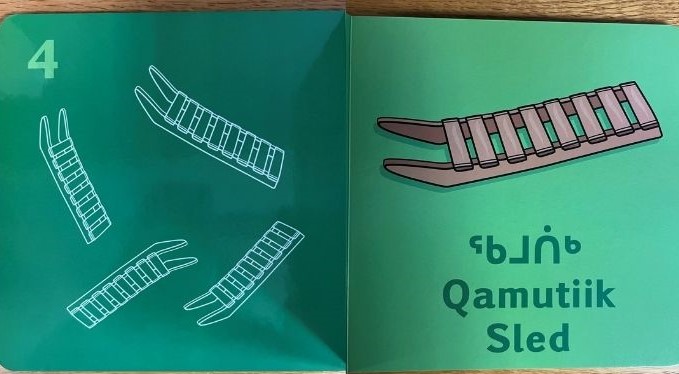 Board book pages showing 4 sleds with text reading ᖃᒧᑏᒃ, qamutiik and sled.