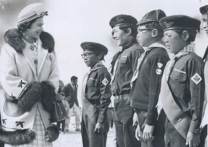 Queen in coat and boy scouts lined up
