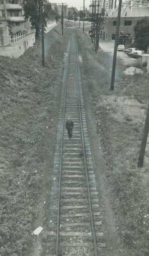 Man walking on train tracks. Photo taken from above.