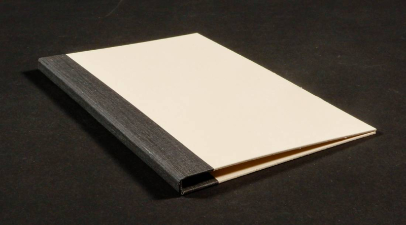 Folder over flaps of binder with black cloth along spine