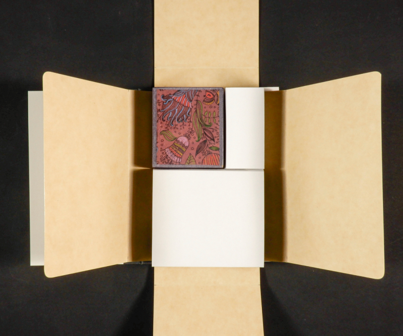 Small book and larger spacers in the centre of four flaps on each side