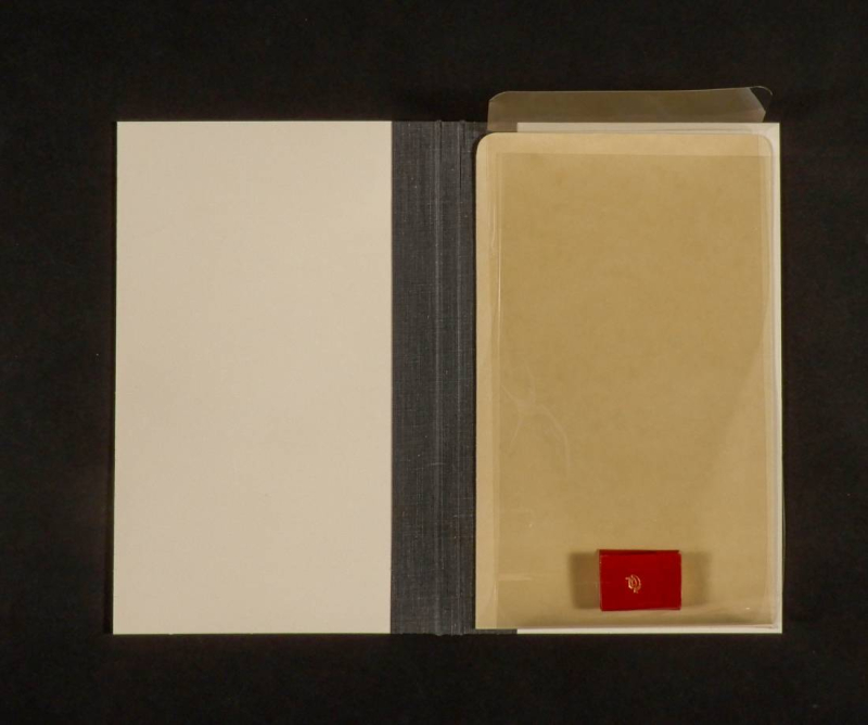 Open custom binder with tiny book in slip inside