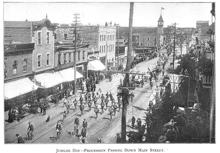 Frame black and white vintage photo of large parade in old street lined with buildings
