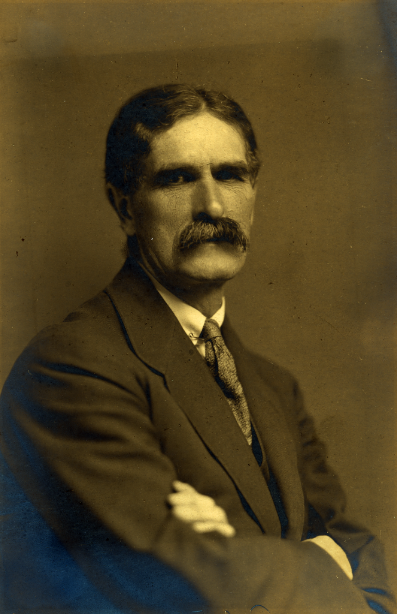 Vintage photo of man posing seriously with arms crossed